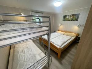 德兰斯克Strandhussiedlung Rügen的小型客房配有两张双层床和另一张床
