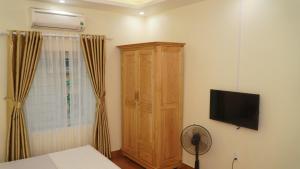 海阳NK Công Đoàn Hải Dương的一间卧室配有木制橱柜和电视