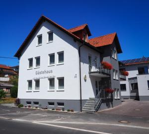 Hammelburg- Obererthal苏姆斯特恩乡村旅馆的白色的建筑,有红色的屋顶