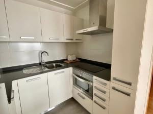 奥伦塞Estudio céntrico 1 con terraza y parking privado的小厨房配有白色橱柜和水槽