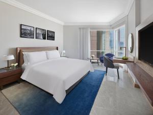 迪拜迪拜费尔蒙特酒店的卧室配有一张白色大床和电视。