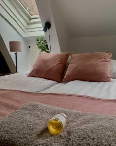斯德哥尔摩Lilla Brunn的一张带两个枕头的床和一瓶