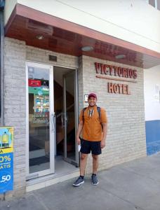 SatipoVicttorios Hotel的一个人站在酒店前
