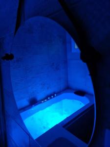 鲁伊德拉Hostal Restaurante La Mancha的浴室设有蓝色灯光浴缸。