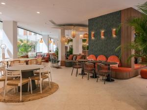 塞维利亚Ibis Styles Sevilla City Santa Justa的餐厅内带桌椅的餐厅