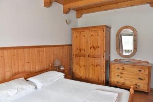 庞迪底雅科Residenza Scoiattolo的一间卧室配有一张床、梳妆台和镜子