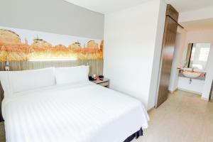 内瓦GHL内瓦酒店的卧室配有白色的床和水槽