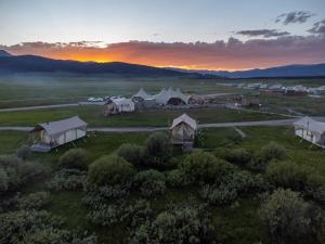 西黄石Under Canvas West Yellowstone的日落时分在田野上观赏帐篷的空中景致