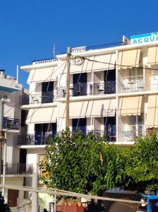 阿吉亚玛丽娜Ammoudia Rooms的白色的公寓楼,上面有时钟