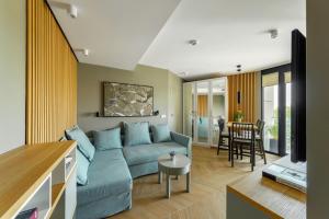 卢布林AURUM PREMIUM SPA UNIA RESIDENCE的客厅配有蓝色的沙发和桌子
