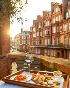 伦敦圣多米尼哥别墅酒店的盘子上放着一盘食物和一杯葡萄酒