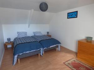 Bégardgite de kerveg的一间卧室配有一张带蓝色棉被的床