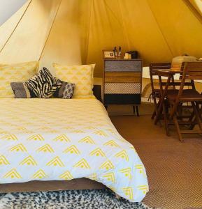 圣吕斯Kawaida - Hébergement insolite - Glamping Makazi的一间卧室配有一张床,帐篷内配有一张桌子