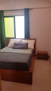 São PedroCasa JPi的一间卧室配有床和蓝色窗帘的窗户