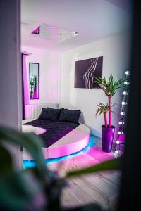 克拉约瓦Apartment de Lux Craiova Jacuzzi Pat Rotund Semineu Zona Ford的一间卧室配有一张粉红色和紫色灯床