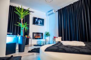 克拉约瓦Apartment de Lux Craiova Jacuzzi Pat Rotund Semineu Zona Ford的一间卧室配有黑色窗帘、一张床和一个壁炉
