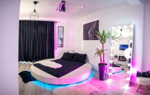 克拉约瓦Apartment de Lux Craiova Jacuzzi Pat Rotund Semineu Zona Ford的一间粉红色和黑色的卧室,卧室内配有一张床铺