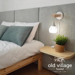 蓬德利马Oldvillage Hostel的一间卧室配有一张床和一张带台灯的桌子