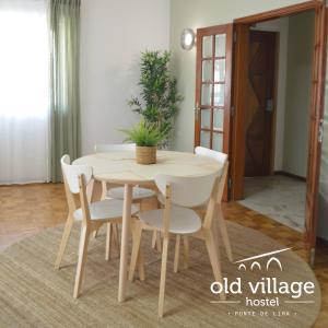 蓬德利马Oldvillage Hostel的一张木桌和椅子