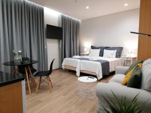丰沙尔Apartments Madeira Funchal City的酒店客房,设有两张床和一张沙发