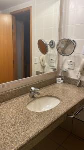 巴西利亚Apartamento no condomínio do Brasil 21 Suites的浴室的柜台设有水槽和镜子