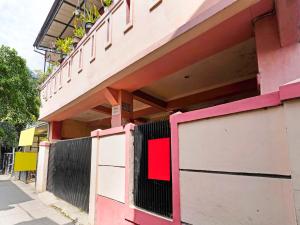 万隆SPOT ON 91367 Rumah Bundo Syariah的粉红色和白色的建筑,设有大门