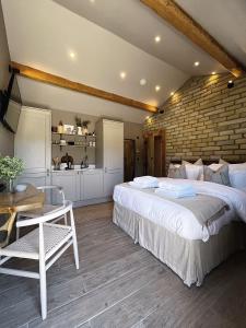 拉姆斯博滕Apartments for two in Brand New Luxury Rural Farmhouse Escape的一间卧室设有一张大床和砖墙