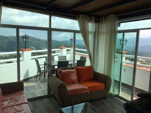 塔斯科·德·阿拉尔孔Casa Vista hermosa de taxco的客厅设有带桌椅的阳台