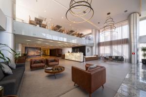 奥萨斯库URBAN by UNU Osasco Hotel的大厅,在大楼里配有沙发和桌子