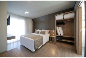 格拉玛多GOLDEN GRAMADO RESORT的卧室设有一张白色大床和大窗户