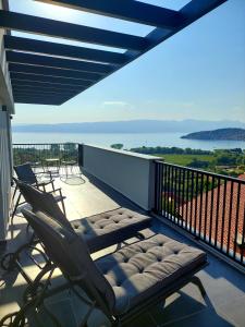 奥赫里德La Vista Luxury Villa的阳台配有两把椅子和长凳