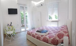 菲纳莱利古雷Borgo and Bike的白色卧室配有粉红色的床和一张桌子