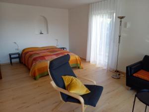 梅尔斯堡Ferienwohnung Riposo的一间卧室配有一张床、一把椅子和一张沙发