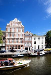 阿姆斯特丹纳斯酒店的一群船在水中,在建筑物前