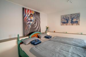 希尔德斯海姆Akram Appartement I - Zentral und Ruhig的卧室配有一张床,墙上挂有绘画作品
