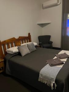 蒂默特Oriental Hotel Tumut的一间卧室配有两张床和椅子