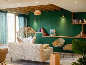 普瓦捷贝斯特韦斯特芒什森林酒店的带沙发和绿色墙壁的客厅
