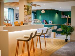 普瓦捷贝斯特韦斯特芒什森林酒店的厨房设有绿色的墙壁和带凳子的台面