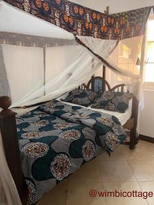 南威Wimbi Cottage的一间卧室配有一张带天蓬的床