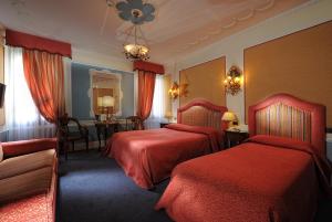 威尼斯阿莱基诺酒店的酒店客房设有两张床和一张桌子。