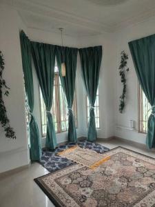 哥打巴鲁3R3B in Kota Bharu near Datu River的客厅配有绿色窗帘和地毯。