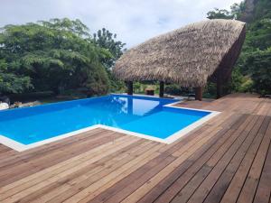 莫雷阿Tokoau Uta的蓝色游泳池和茅草屋顶的度假胜地