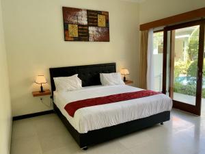 努沙杜瓦Davit Guesthouse Nusa Dua的一间卧室设有一张大床和一个窗户。