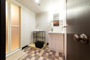 福冈博多入住公寓的一间带水槽、卫生间和镜子的浴室