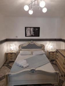 佩里萨马科斯别墅酒店的一间卧室配有一张带2个床头柜的大床