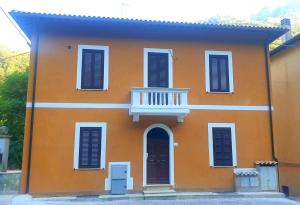 Le MarmoreAria Marmore的橙色的房子,设有白色阳台和门