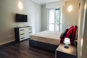 米兰Residenza Vigliani的一间卧室配有一张床、梳妆台和电视。