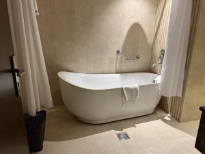 泰布克Swiss In Tabuk Hotel的浴室内设有一个白色浴缸