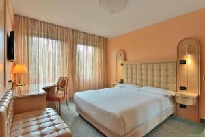 比耶拉阿戈拉皇宫酒店的酒店客房设有一张大床和一张沙发。