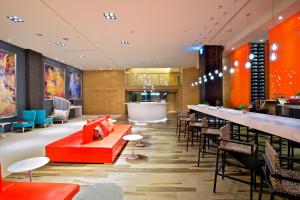 高雄富驿商旅高雄中华路馆 的一间设有红色沙发的餐厅和一间酒吧
